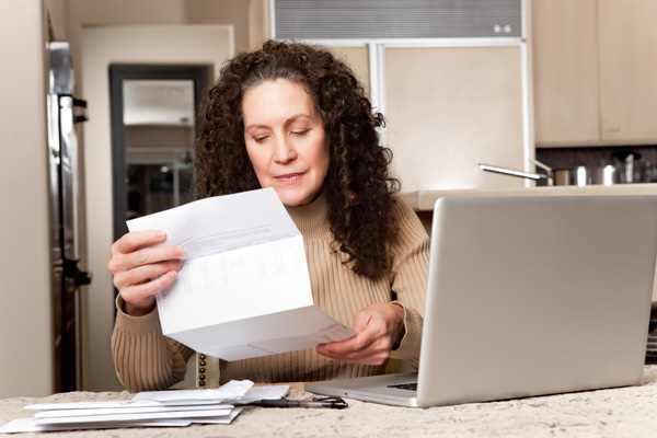 image of woman paying her energy bill and home heating costs