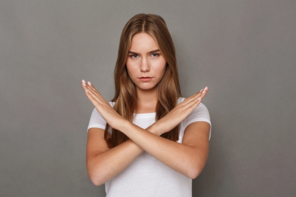 woman making a stop sign by crossing her hands depicting Prevent Expensive HVAC Failures