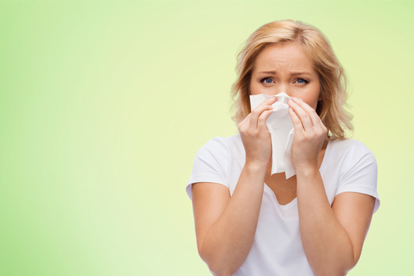 woman experiencing allergies at home due to poor indoor air quality