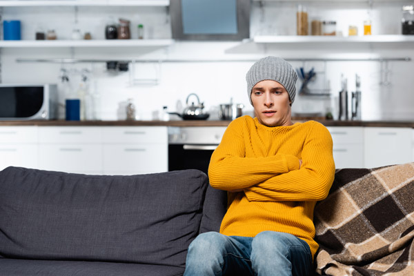 image of homeowner feeling chilly due to short cycling furnace