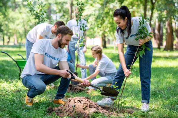 family planting trees to help with net zero emissions