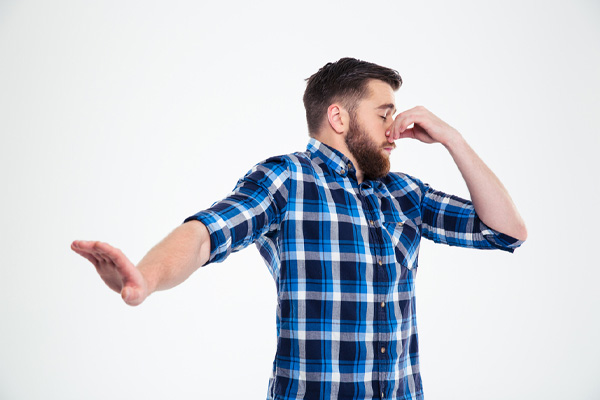 image of a homeowner plugging nose due to dead animal in ductwork