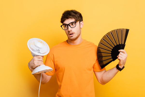 man cooling hirself with a fan