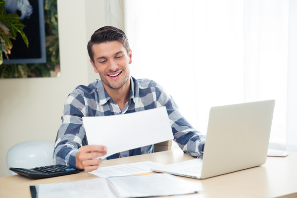 Man checking cooling bills on the tablet at home