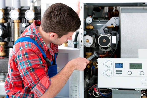 hvac technician repairing heating boiler