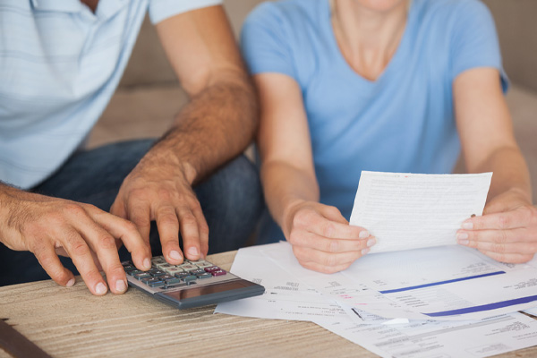 couple with home heating bills and calculator