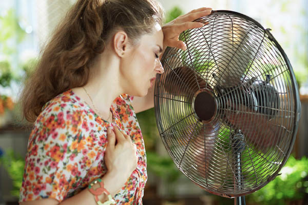 image of homeowner feeling hot due to a leak in hvac ductwork