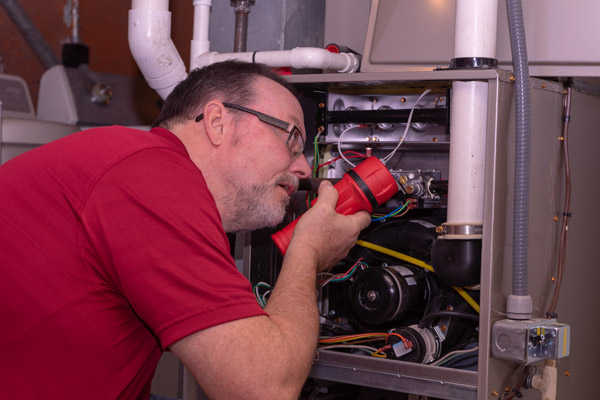 image of a furnace technician tuning up furnace hvac system