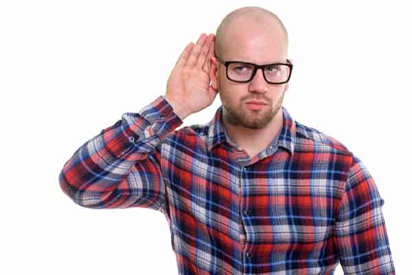 image of a homeowner cupping ear and listening due to unusual boiler noises