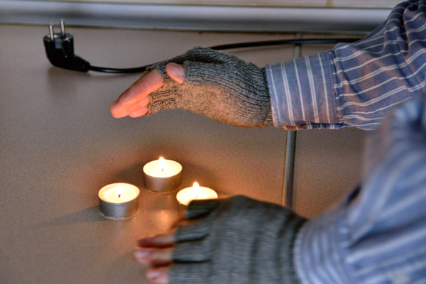 image of a homeowner during power outage using candles for heat