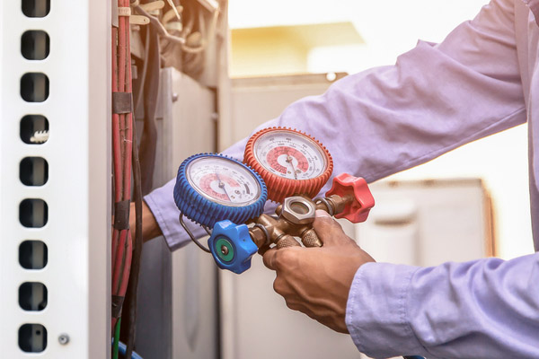 image of an hvac contractor examining ac unit refrigerant levels