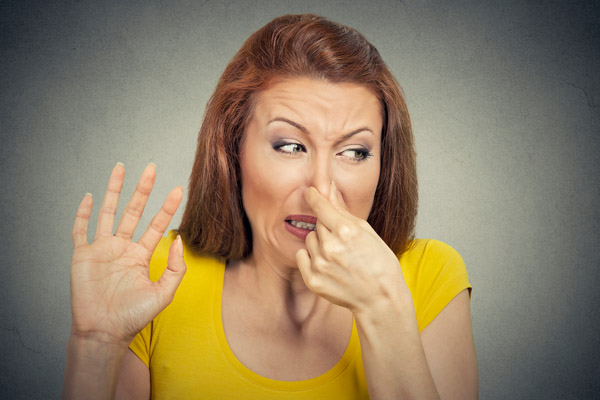 woman plugging nose due to smelly air conditioner