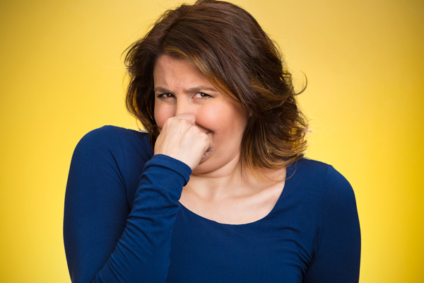 image of a homeowner plugging nose due to furnace unit burning smells