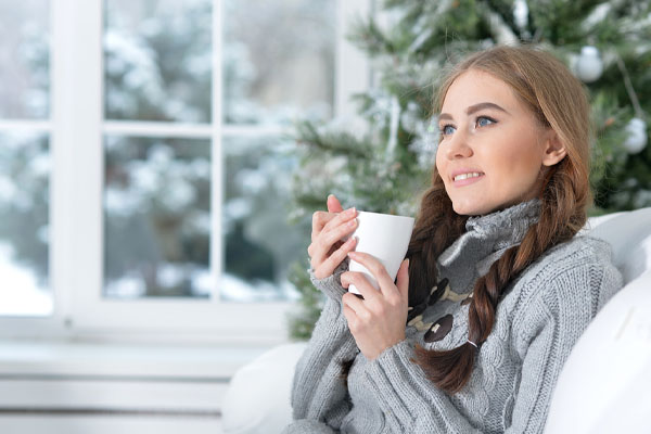 image of a homeowner relaxing at home in winter due to energy-efficient home heating