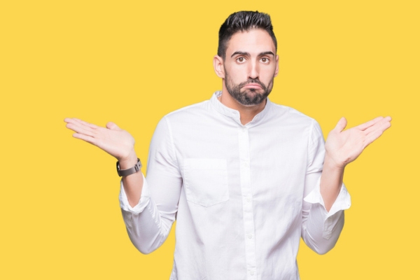 man shrugging depicting comparison between Ductless vs. Central HVAC Systems