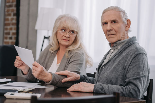 image of an elderly couple worried about home energy bills due lack of furnace maintenance