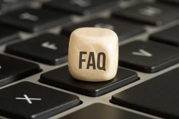 FAQ written on a wooden dice on top of a computer keyboard depicting questions about Ductless HVAC vs. Window Air Conditioning Systems