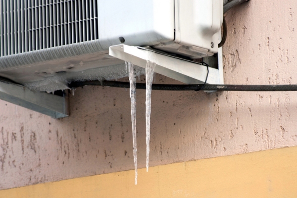 air conditioner condenser with icicle depicting frozen AC