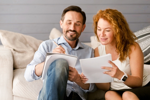 couple comparing notes depictimg comparing ductless heat pump and ductless air conditioners