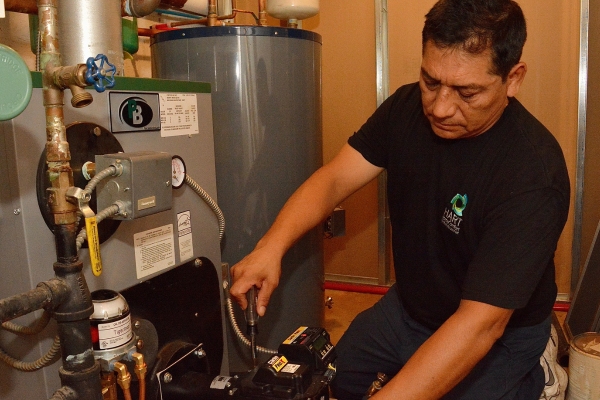 Hart Home Comfort HVAC technician servicing a boiler