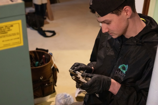 Hart Home Comfort HVAC technician inspecting furnace part