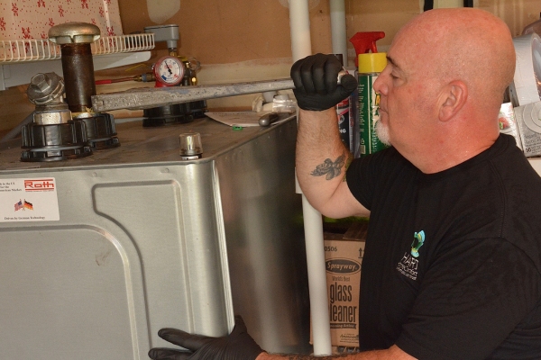Hart Home Comfort professional technician tending to an oil tank