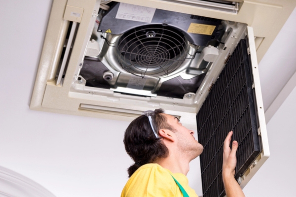 HVAC technician checking home air conditioner indoor unit