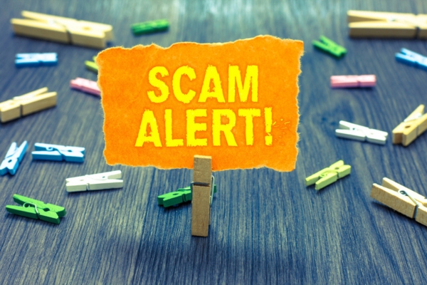 Scam Alert written on a torn paper displayed on a mini clip depicting Fraudulent HVAC Practices