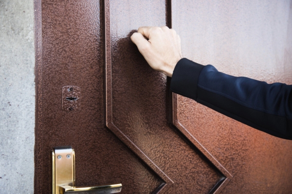man knocking on door depicting Door-to-Door Sales Pitches