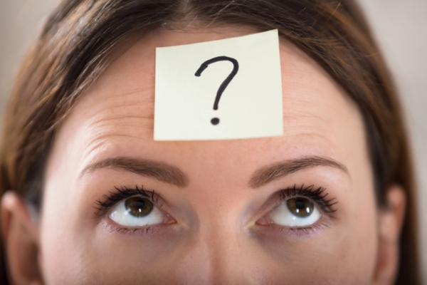 woman's forehead with question mark on a sticky note depicting Air Conditioning Scams FAQs