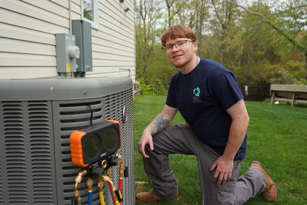 Babylon, NY technician performing air conditioning repair next to outdoor unit
