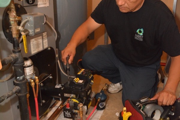 Plainview, NY technician performing maintenance on a heating system with tools and equipment