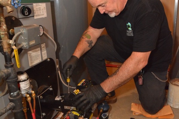 Plainview, NY technician performing heating service and repair on a furnace unit