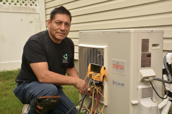 Babylon, NY technician performing maintenance on an outdoor air conditioning unit