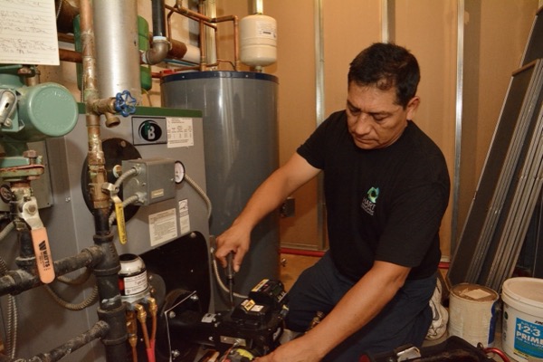 Plainview, NY technician performing maintenance on a boiler and furnace system