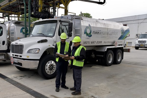 Albertson, NY technicians reviewing delivery plans near a propane delivery truck