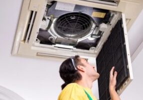 HVAC technician checking home air conditioner indoor unit