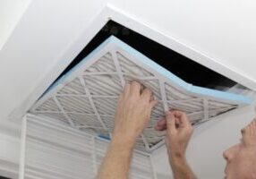 homeowner checking HVAC air filter on the ceiling
