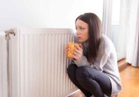image of a homeowner in front of radiator due to boiler problems